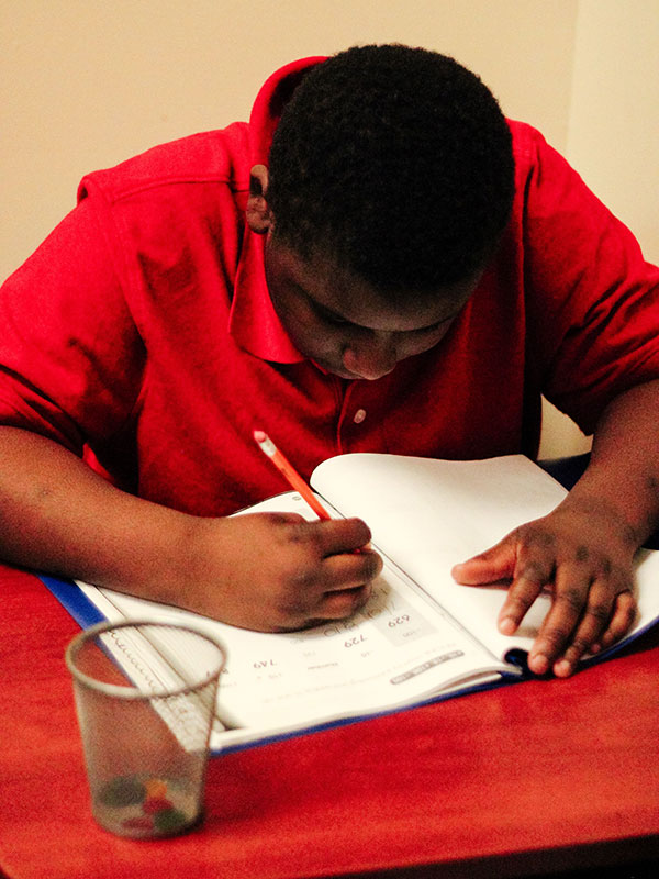 a student is writing in his copybook