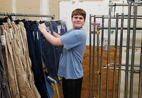 a boy taking a pair of trousers